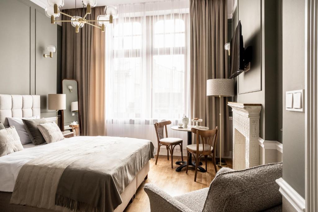 - une chambre avec un lit, une table et des chaises dans l'établissement Avanti Palazzo, à Cracovie
