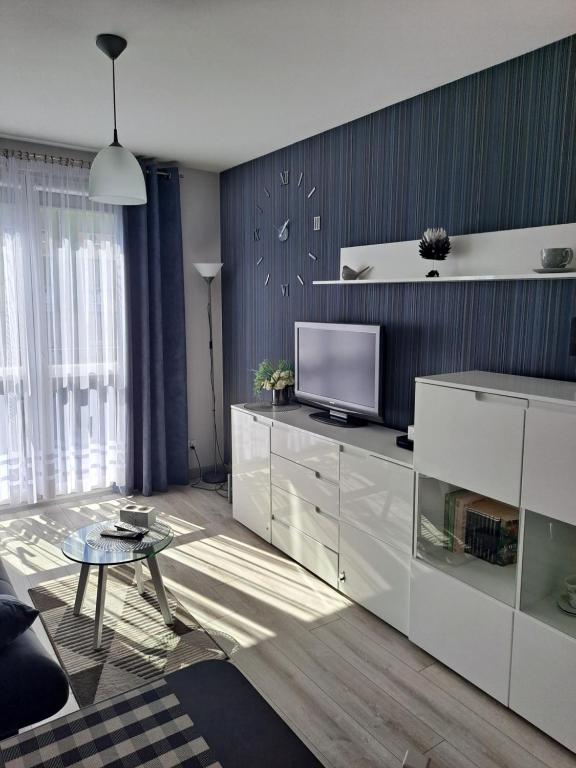 een woonkamer met een televisie en een tafel. bij Studio Zabobrze in Jelenia Góra