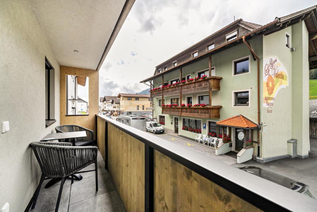 a balcony with two chairs and a building at Ferienwohnung Lamm 3 in San Valentino alla Muta