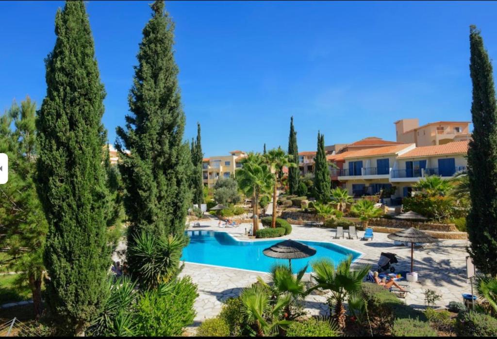 a view of a resort with a swimming pool and trees at New cozy Villa near the beaches in the Magnificent Gardens of Regina with swimming pools! in Paphos City