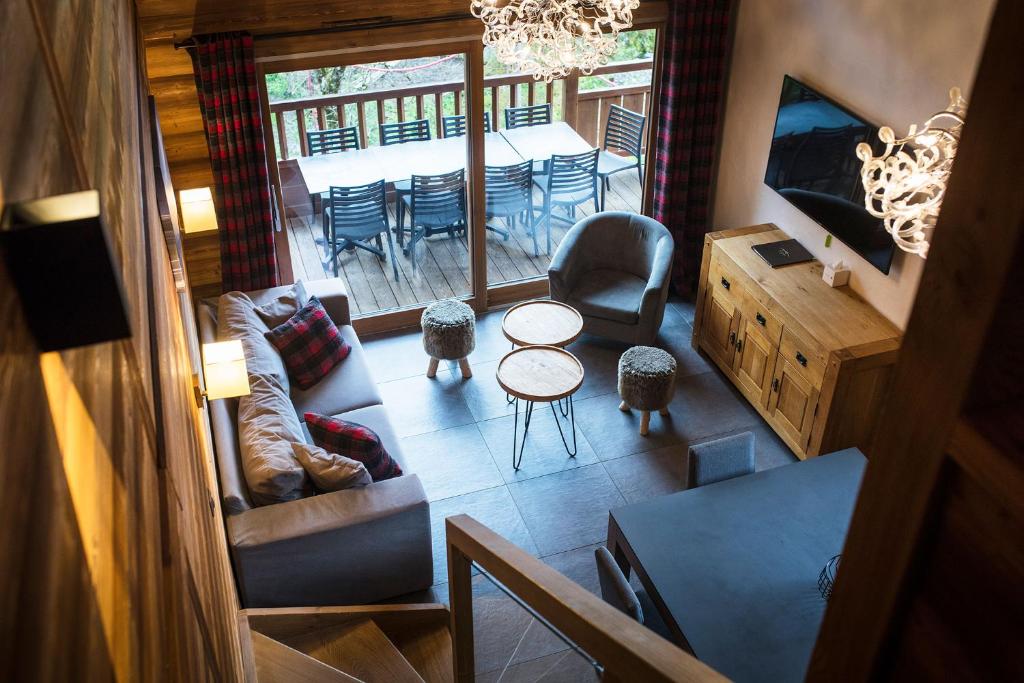 a view of a living room with a table and chairs at Les Cimes in La Clusaz