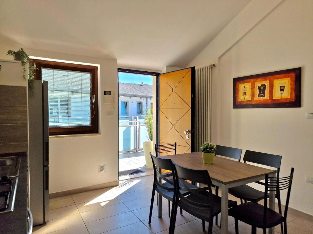 cocina y comedor con mesa y sillas en Casa Elena by TraMonti Apartments en LʼAquila