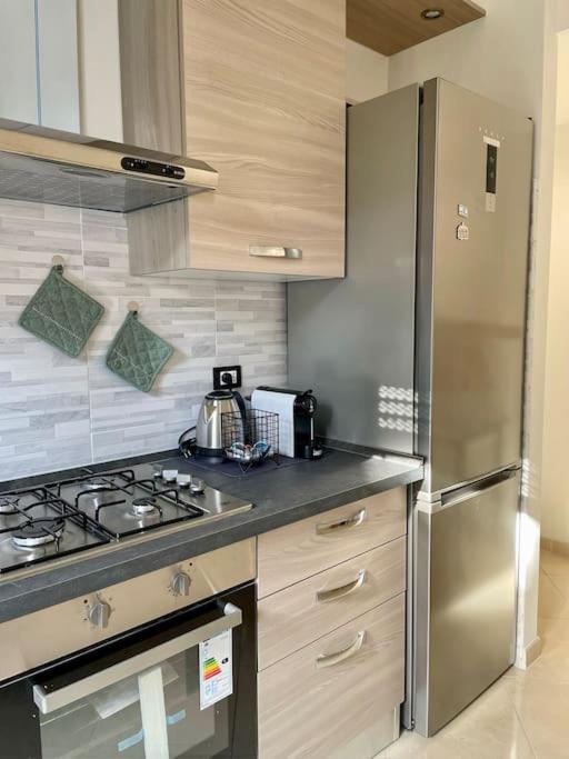uma cozinha com um fogão e um frigorífico de aço inoxidável em Guest House (15 min metro dal Duomo) em Milão