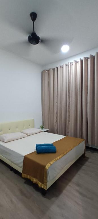 Un dormitorio con una cama con una almohada azul. en Singgahsini Guesthouse Putrajaya en Putrajaya