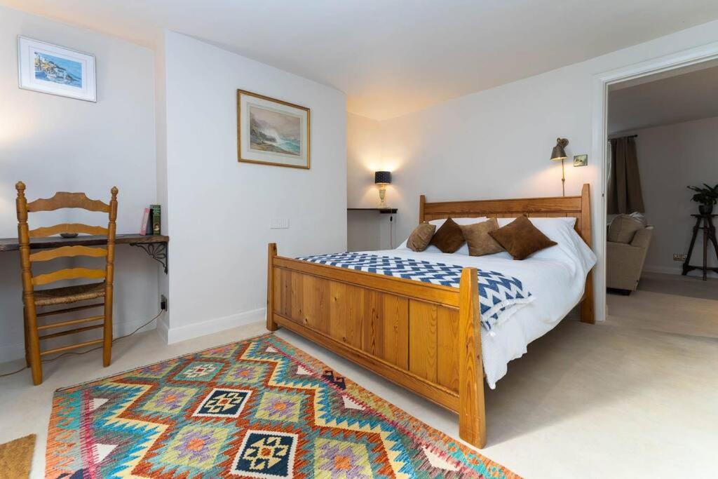a bedroom with a wooden bed and a rug at Lovely Flat Ensuite Bathroom Private Courtyard in Brighton & Hove