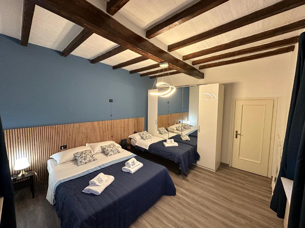 een kamer met 3 bedden en een spiegel bij AOSTA 3 in Parma