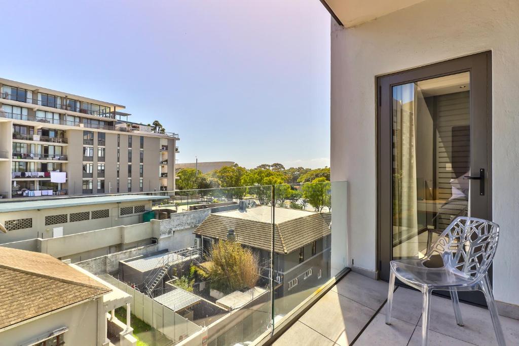 a balcony with a chair and a view of a building at Chelsea on Main in Cape Town
