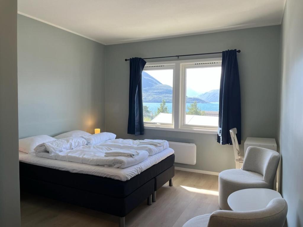 um quarto com uma cama, uma cadeira e uma janela em Skibotn Hotel em Skibotn