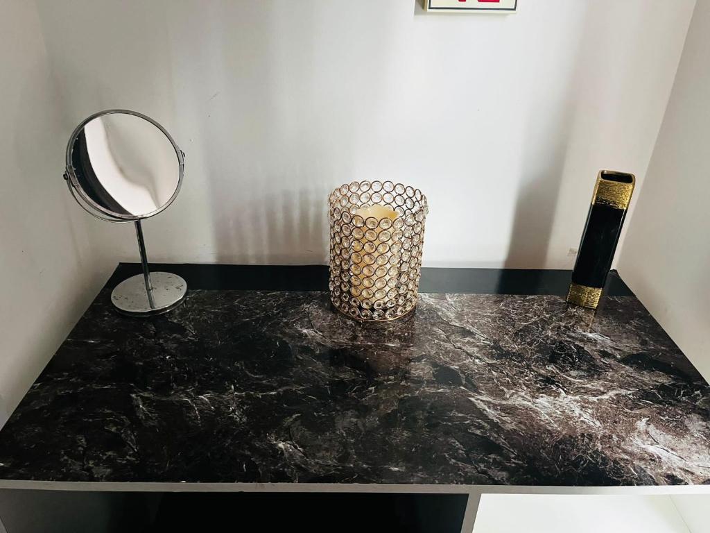 a black counter with a mirror and a lamp on it at Coventry City House - Room 2 in Coventry