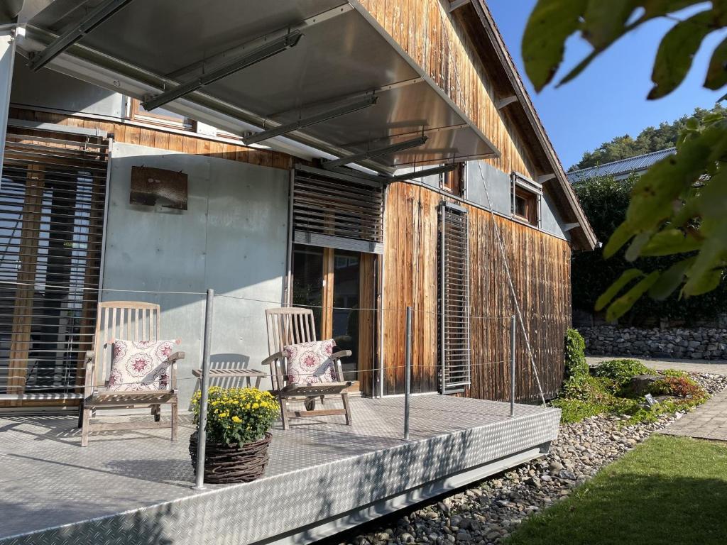 two chairs sitting on a porch of a house at Ferienhaus Sonnenchalet in Bodman-Ludwigshafen