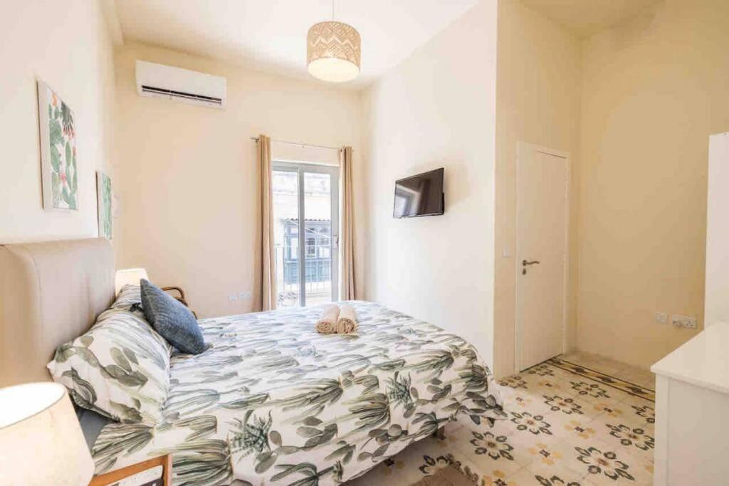 un dormitorio con una cama con un animal de peluche en Birgu 3, en Cospicua