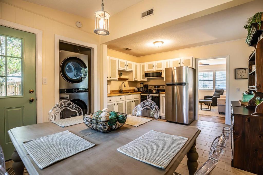 Una cocina con una mesa y un refrigerador de acero inoxidable. en Port Royal 1721 Battery Park Drive, en Beaufort