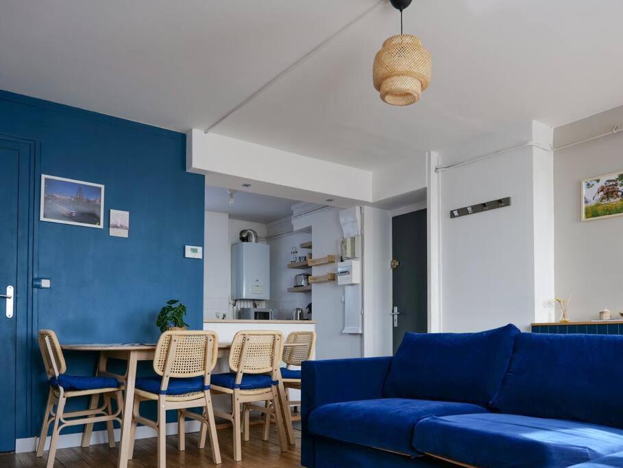a living room with a blue couch and a table at Parenthèse nantaise, charmant T2 cosy et décoré, ambiance Halloween garantie in Nantes