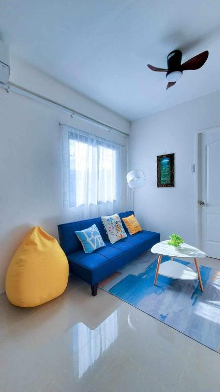 a living room with a blue couch and a table at Urban oasis40 in Talisay