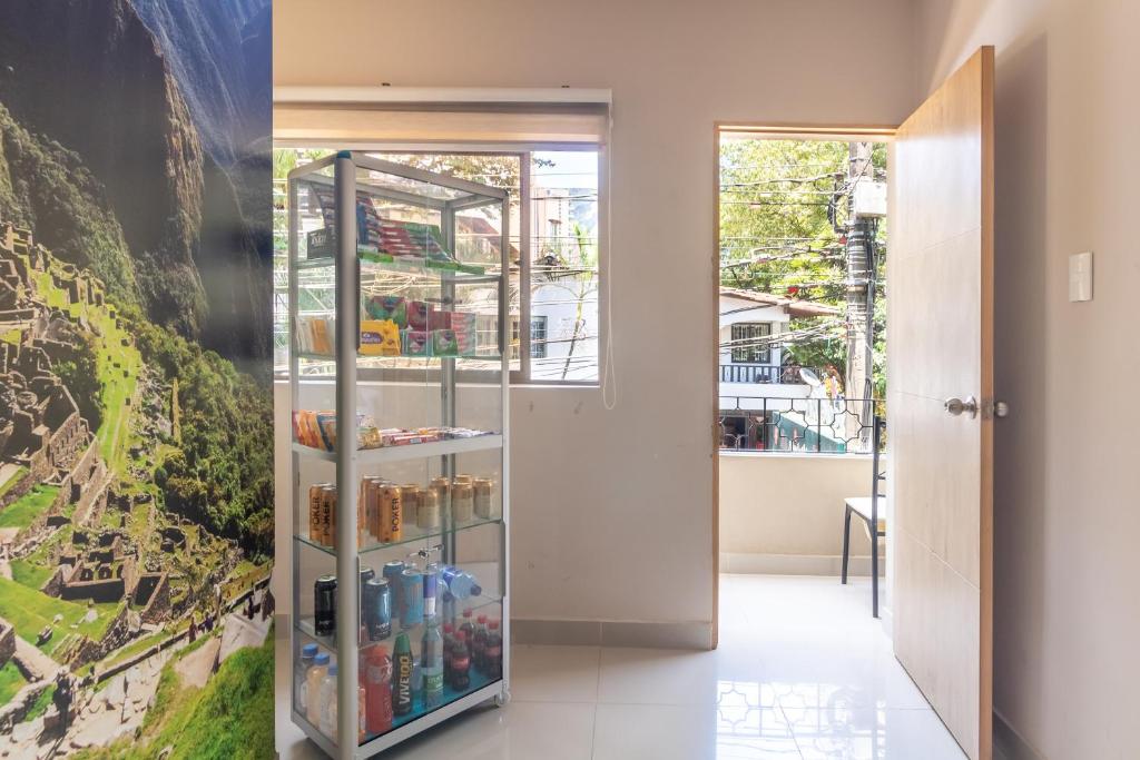 - un réfrigérateur en verre dans le couloir orné d'une peinture dans l'établissement CASA TURISTICA MACHU PICCHU MEDELLIN, à Medellín