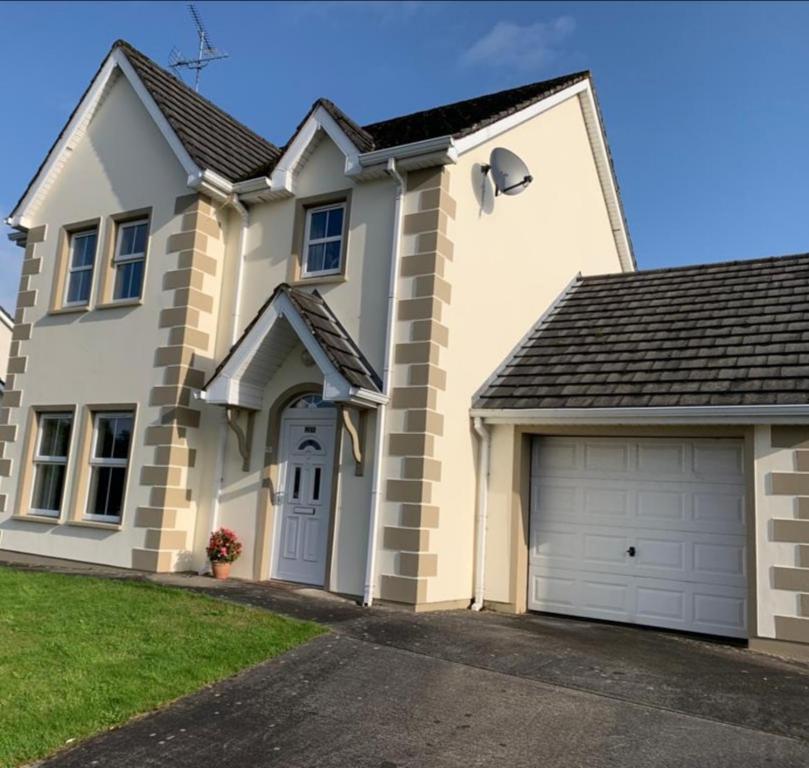 a large white house with a garage at Elm Park Escape - 4 bed self-catering holiday home in Buncrana