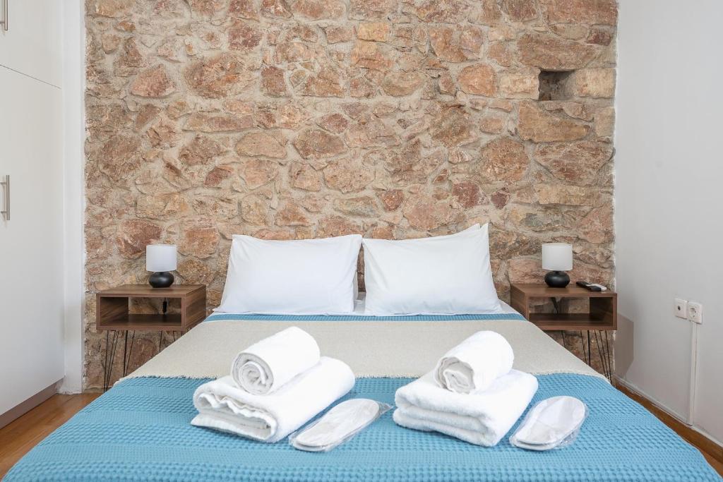 een slaapkamer met een bed met handdoeken erop bij CONTEMPORARY APARTMENT 200M FROM ACROPOLIS 100Mbps NETFLIX in Athene