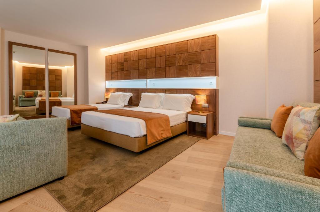 a hotel room with a bed and a couch at Hotel Alvorada in Estoril