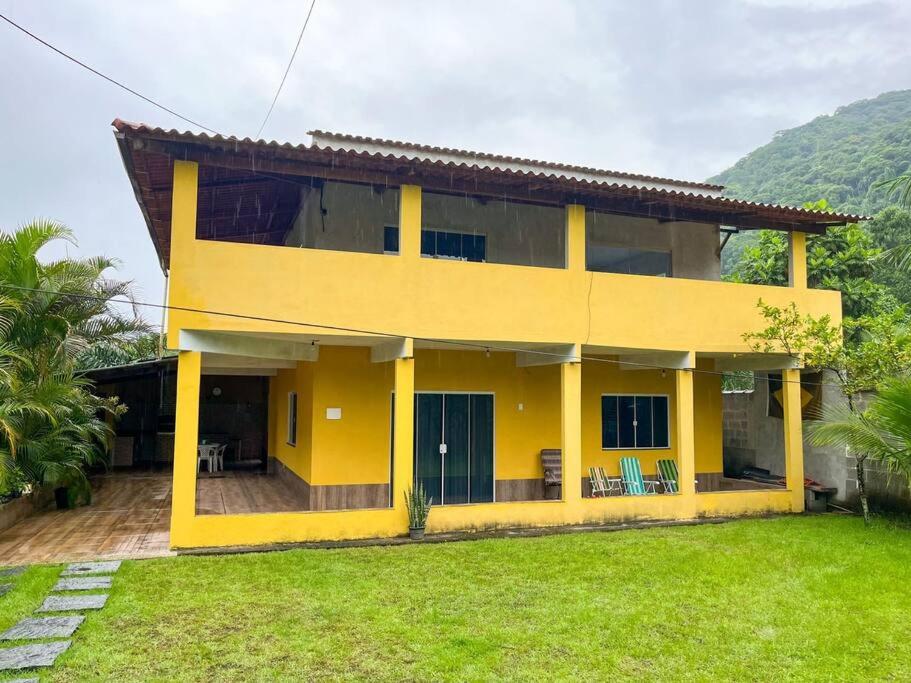 アングラ・ドス・レイスにあるCasa com churrasqueira e piscina, perto de riachoの前方の芝生の黄色い家