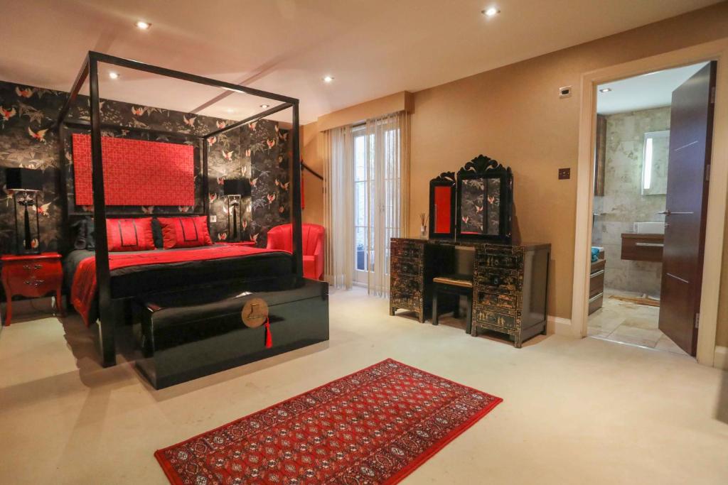 a bedroom with a red bed and a mirror at The London Nest: 2BR City Haven in London