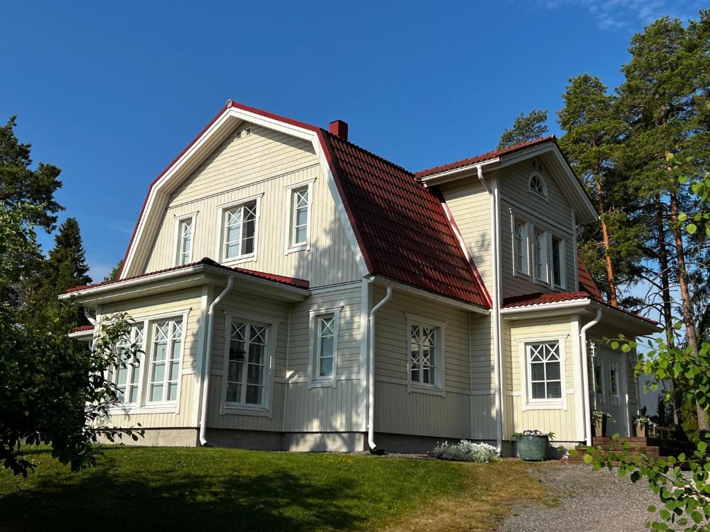 une maison blanche avec un toit rouge dans l'établissement Moonloft@VillaSolbacka, à Inkoo