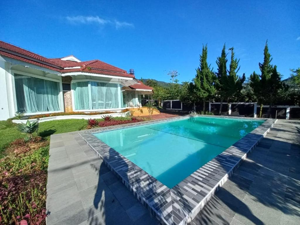 een zwembad in de achtertuin van een huis bij Villa Ciloto Ambarita in Cimacan