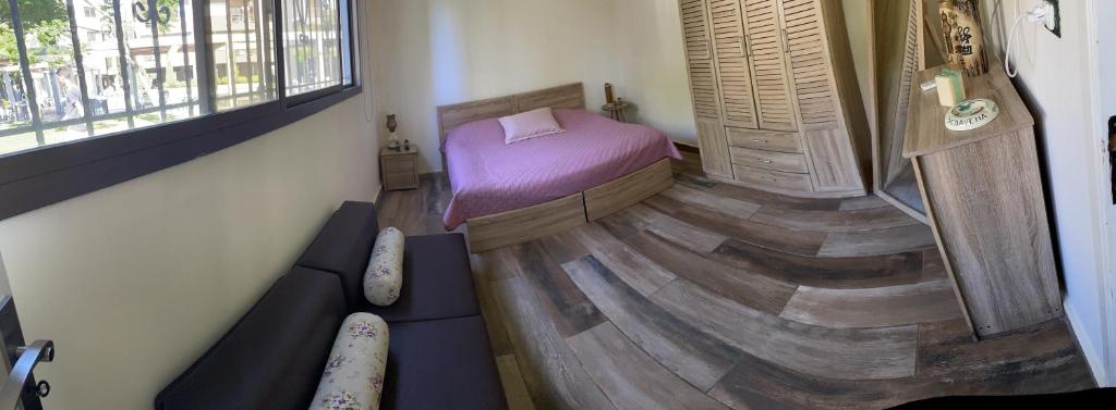 małą sypialnię z łóżkiem i drewnianą podłogą w obiekcie Batroun chalet in front of the pool - Batrouna Park Resort 