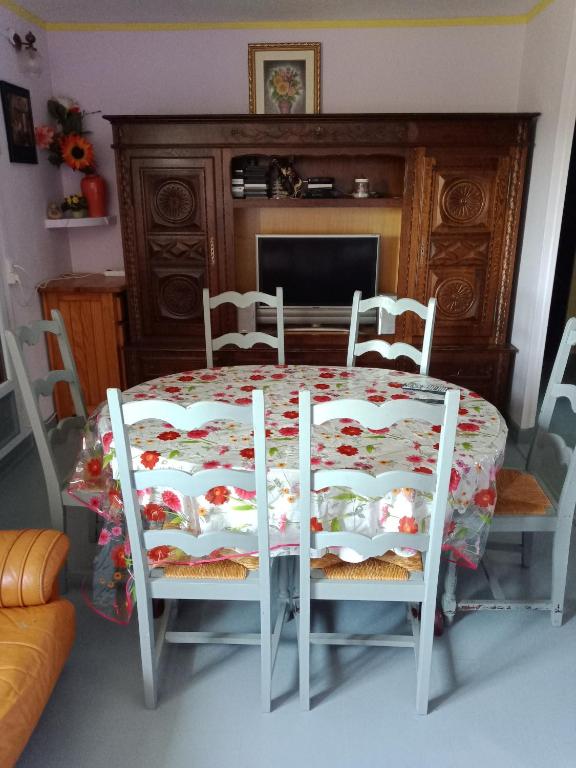 stół jadalny i krzesła ze stołem i kominkiem w obiekcie Maison complète w mieście Montluçon