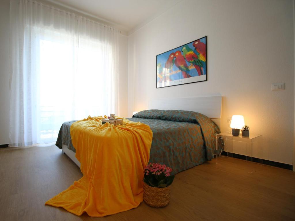 Un dormitorio con una cama con una sábana amarilla. en Il mare in Piazza, en Albisola Superiore