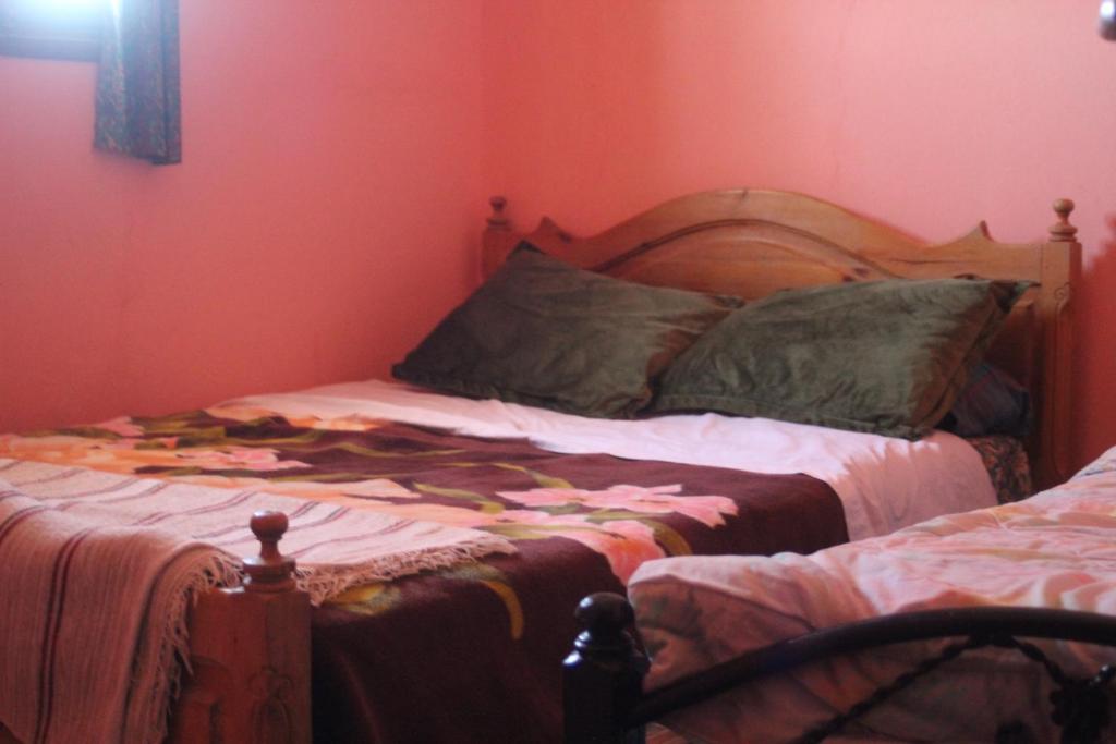 1 dormitorio con 1 cama en una pared roja en auberge le SIRWA SALAM, en Ouarzazate