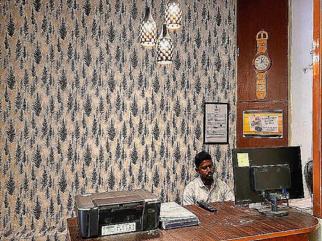a man sitting at a desk with a computer at Flagship Le Pondy Paradise in Puducherry
