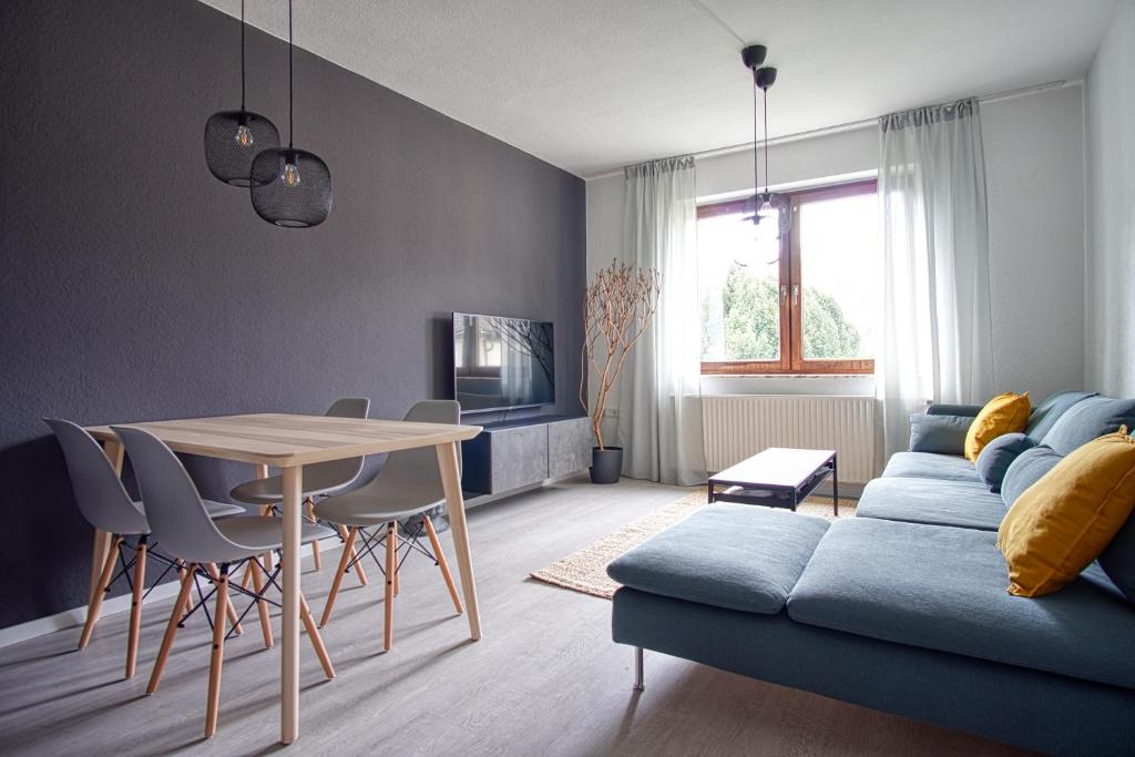 een woonkamer met een tafel en een blauwe bank bij Homefy Family Apartment mit Netflix in Essen