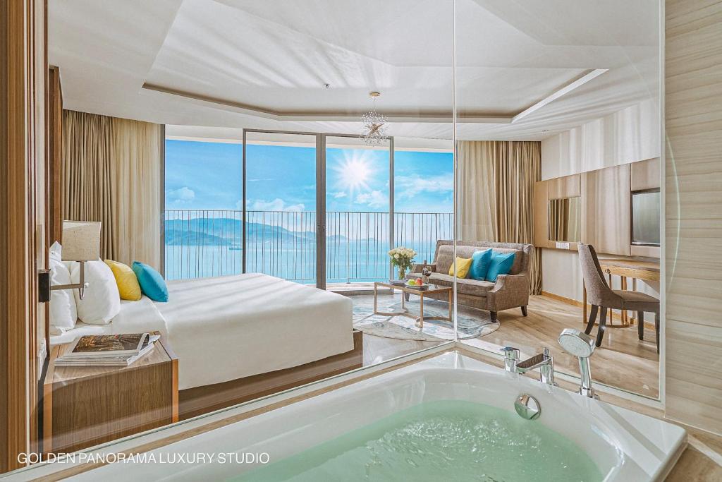 GOLDEN PANORAMA LUXURY STUDIO في نها ترانغ: غرفة في الفندق مع سرير وحوض استحمام