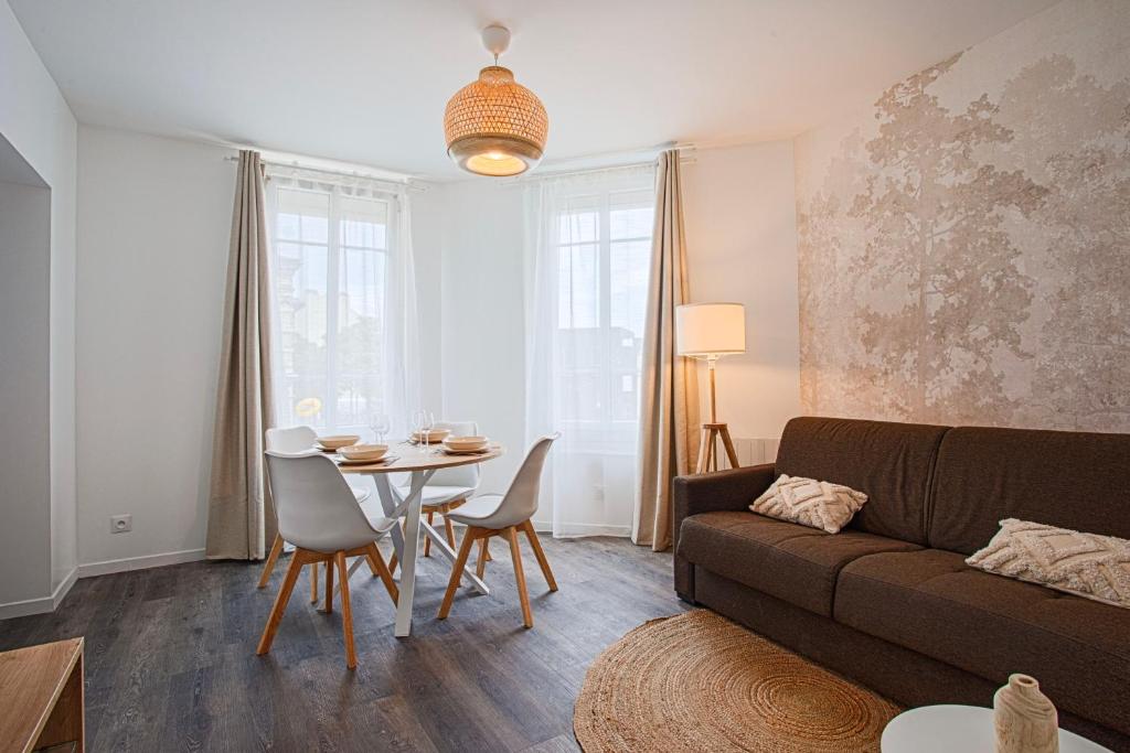 un salon avec un canapé, une table et des chaises dans l'établissement Le Havre - Quartier des Docks au Calme - Appartement T3 Entièrement Rénové, au Havre
