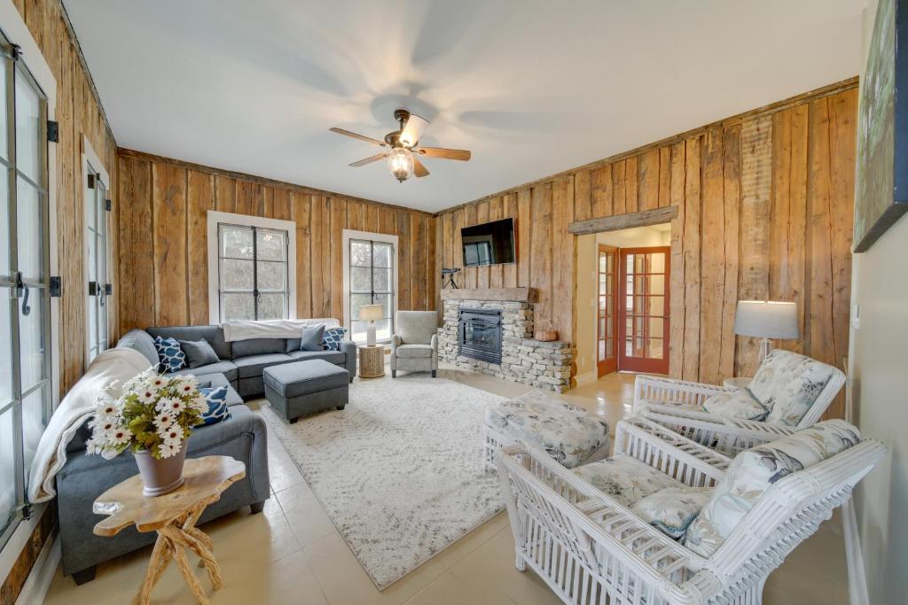 a living room with wooden walls and a ceiling fan at Spacious Loon Lake Retreat Dock and Mtn Views! in Loon Lake