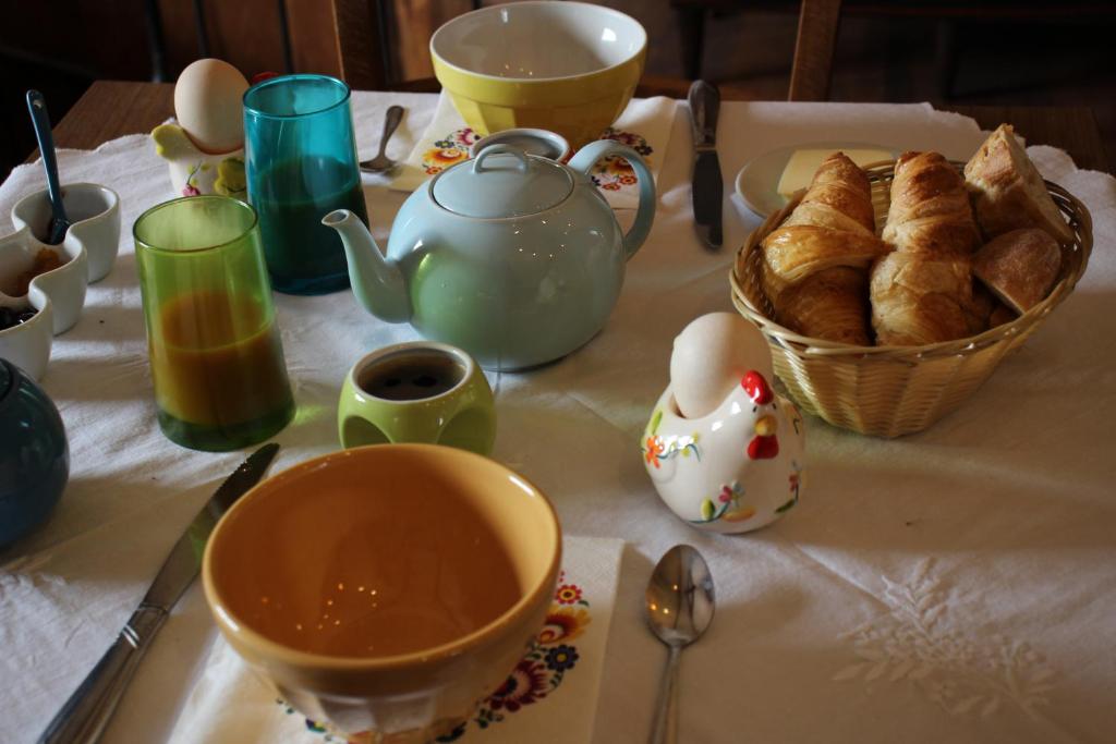 - une table avec une tasse de thé et un panier de pain dans l'établissement LE MONTESSER, 