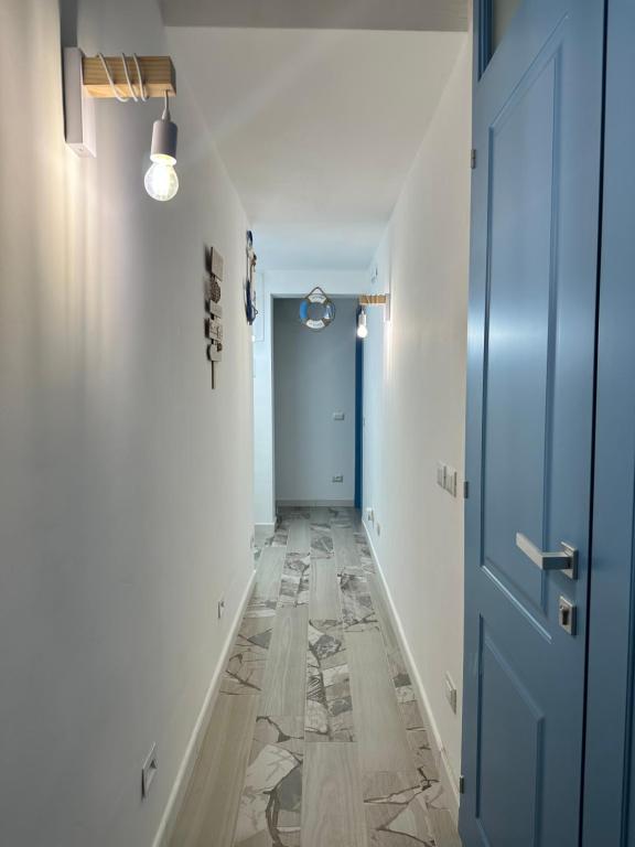 a hallway with a blue door and a tile floor at Le Case del Marinaio in San Vito lo Capo
