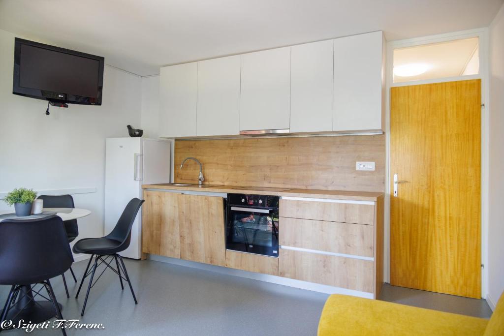 een keuken met witte kasten en een tafel en stoelen bij Apartment Sleeps 4 with Free Parking in Rijeka