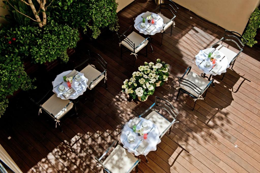 una terraza con vistas panorámicas a las mesas y sillas en The Fifteen Keys Hotel en Roma