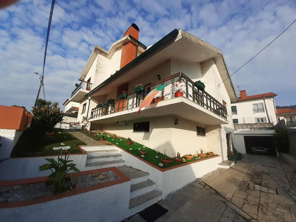 ein weißes Haus mit einem Balkon an der Seite in der Unterkunft Morada do Ultramar in Viana do Castelo