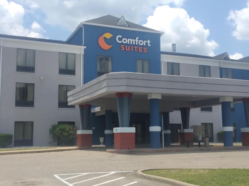 a hotel with a sign on the front of a building at Comfort Suites Airport South in Montgomery