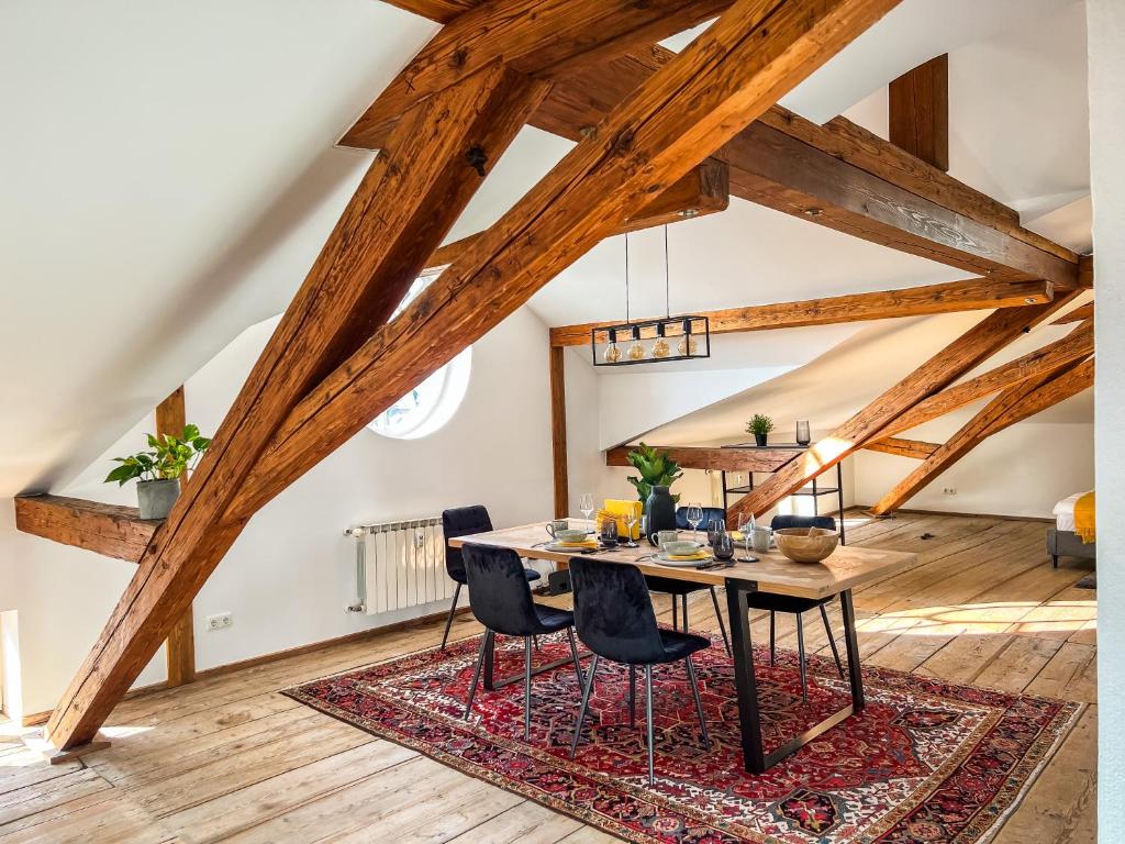 una sala da pranzo con tavolo e sedie su un tappeto di Loft-Wohnung im Herzen von Prien - 100m2 - SmartTV a Prien am Chiemsee