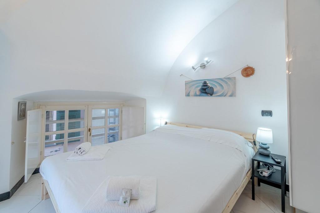 une chambre blanche avec un lit et une fenêtre dans l'établissement Grillo Cattaneo Central Studio, à Gênes