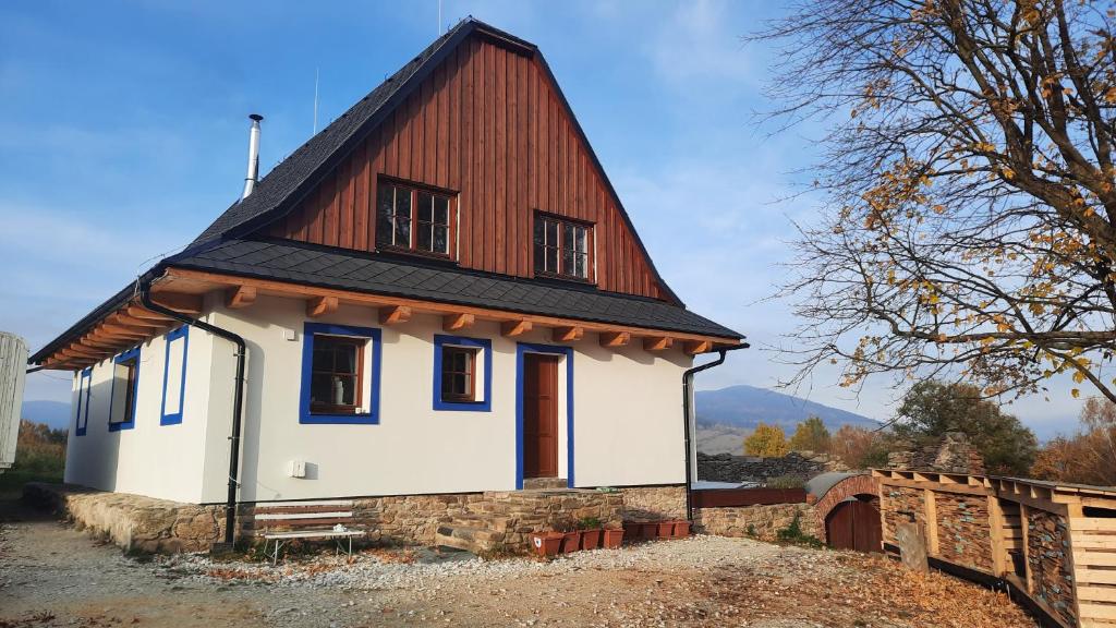 una pequeña casa blanca con techo marrón en Zlatak holiday house en Malá Morava