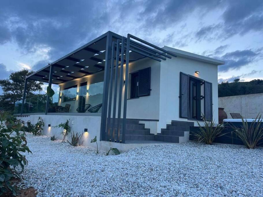 ein kleines weißes Haus mit schwarzen Fenstern und Treppen in der Unterkunft Ek Ornelakis, Luxury Country House with Jacuzzi in Chania