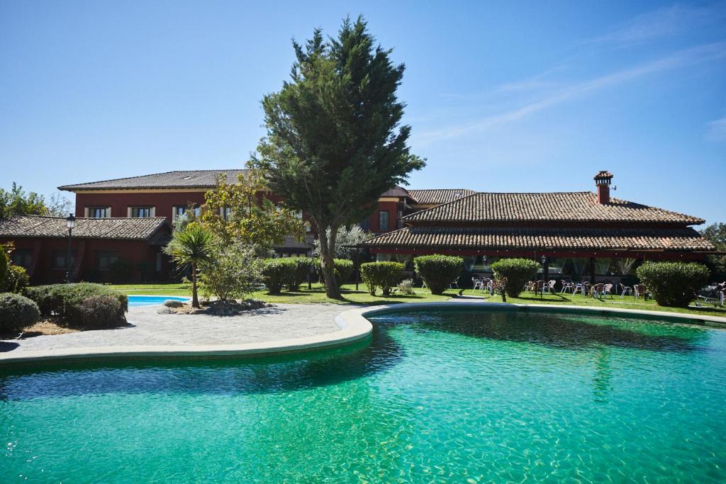 una gran piscina de agua frente a un edificio en Hotel El Mirlo Blanco en Candeleda