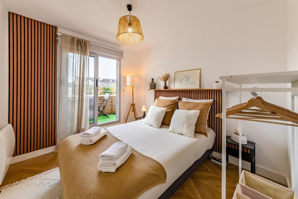 - une chambre avec un grand lit et des serviettes dans l'établissement Le Dobrée - Centre - Charme & Confort - 4p - 55m2, à Nantes