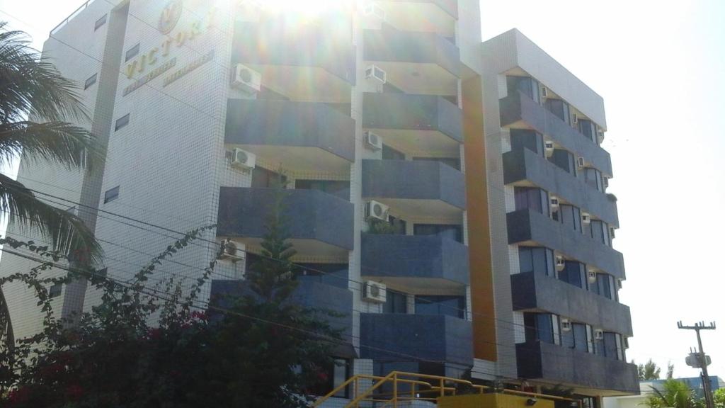 a tall building with blue balconies on the side of it at Flat Victory Intermares in Cabedelo