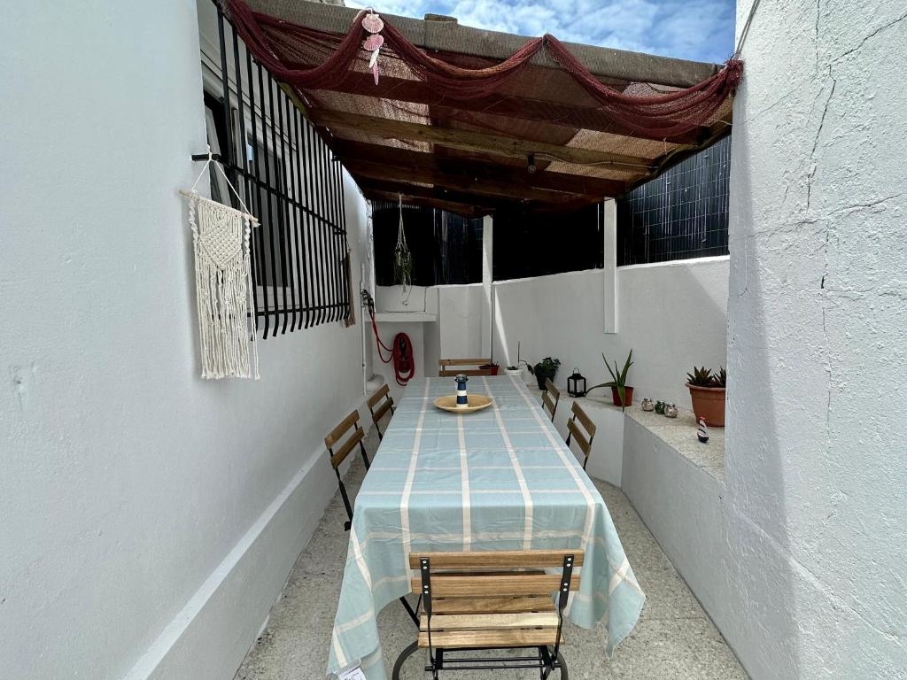 un patio con tavolo e sedie sul balcone. di CasaLola - Corme Porto a La Coruña
