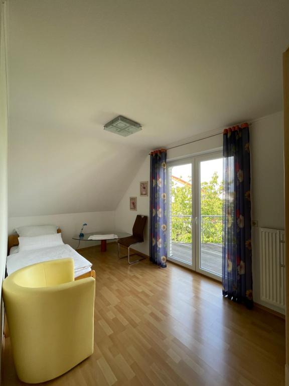 um quarto com uma cama e uma cadeira amarela em Messe Apartment - 10 Gäste em Hanôver
